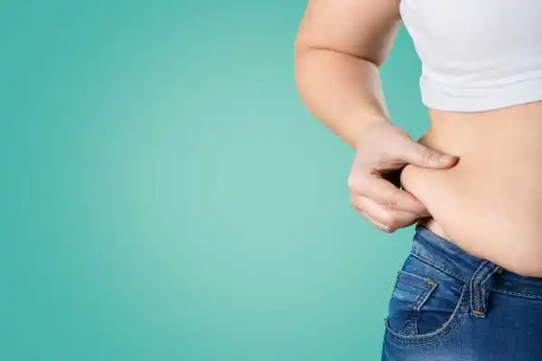 Image of woman pinching her love handles to show weight gain Beccles